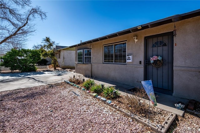 exterior space with driveway, a patio area, and stucco siding