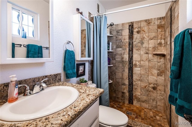 full bathroom featuring toilet, a shower stall, and vanity