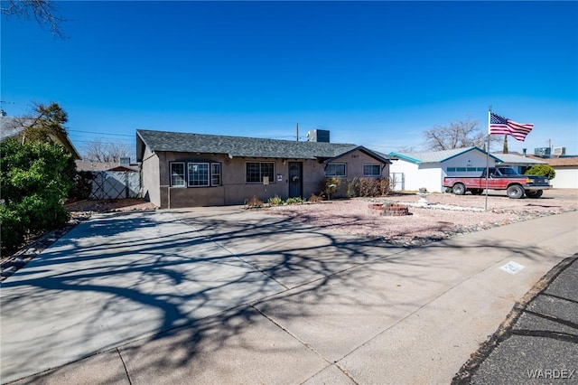 single story home with fence, concrete driveway, and stucco siding