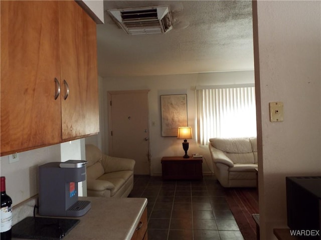 living room with dark tile patterned flooring, visible vents, and a textured ceiling