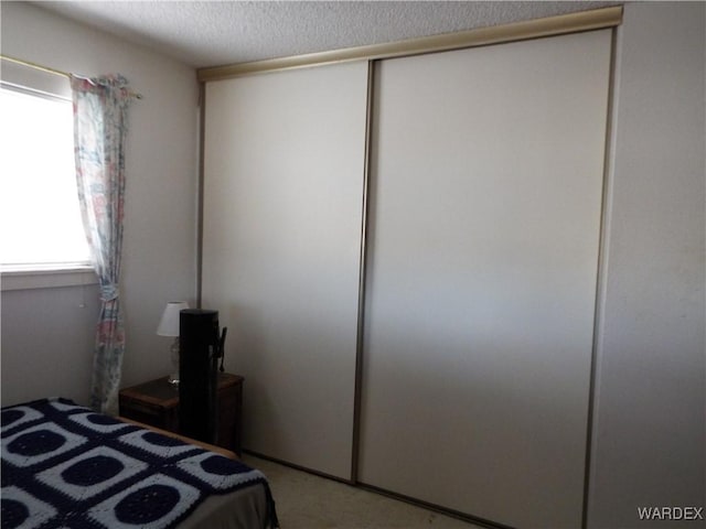 unfurnished bedroom with a textured ceiling and a closet