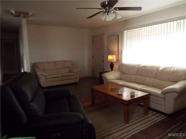 living area featuring ceiling fan and visible vents