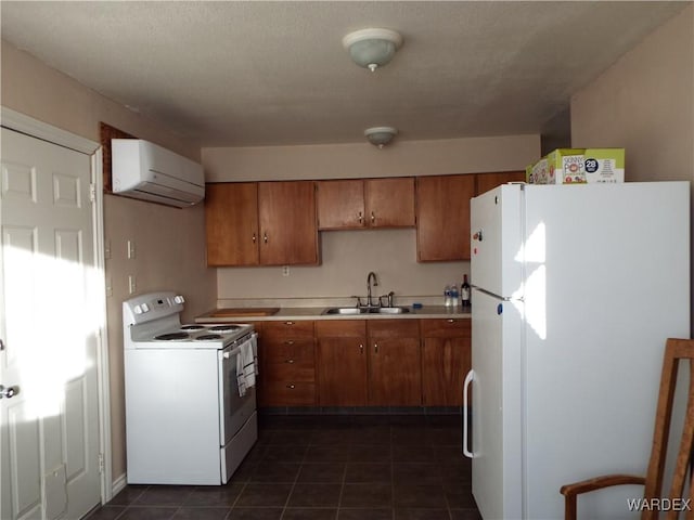 kitchen featuring brown cabinets, light countertops, a wall mounted AC, a sink, and white appliances