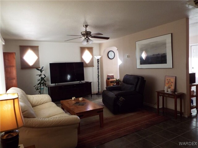 living area featuring dark tile patterned flooring and ceiling fan