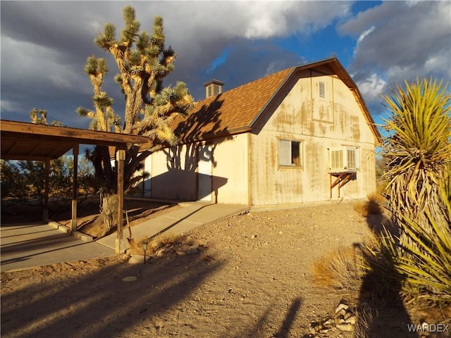 back of property with roof with shingles and a gambrel roof