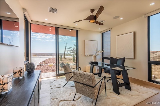 home office with light wood-style floors, recessed lighting, visible vents, and floor to ceiling windows