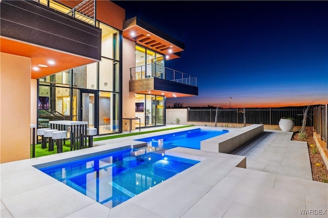 view of swimming pool with a patio area, fence, a fenced in pool, and an in ground hot tub