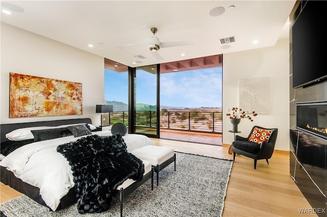 bedroom featuring visible vents, wood finished floors, access to exterior, floor to ceiling windows, and recessed lighting