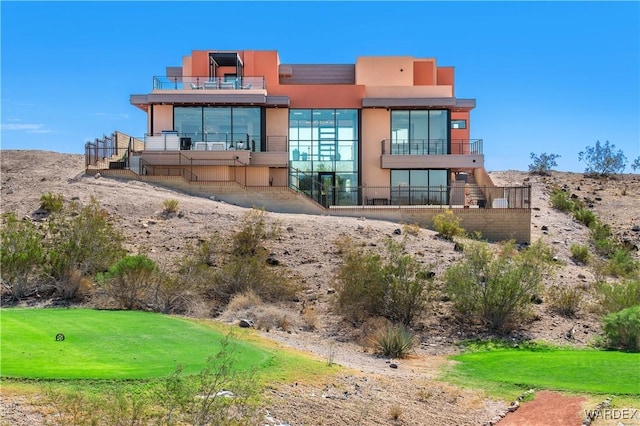 back of house featuring a yard and stucco siding