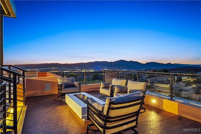 view of patio with a mountain view and an outdoor living space with a fire pit