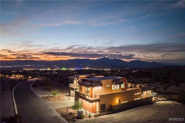 exterior space with a mountain view, a balcony, and stucco siding