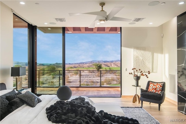 bedroom featuring expansive windows, visible vents, and wood finished floors