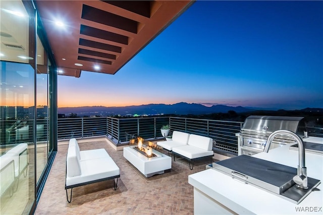 view of patio / terrace with visible vents, a mountain view, area for grilling, and an outdoor living space with a fire pit