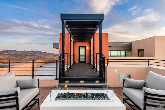 exterior space with an outdoor living space with a fire pit, a mountain view, and a balcony