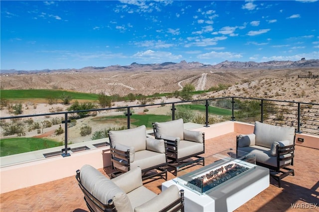 view of patio / terrace featuring an outdoor living space with a fire pit and a mountain view