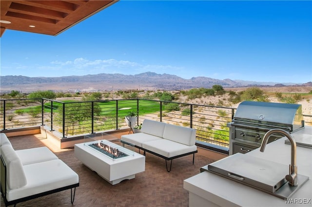 balcony featuring an outdoor living space with a fire pit, a mountain view, and area for grilling