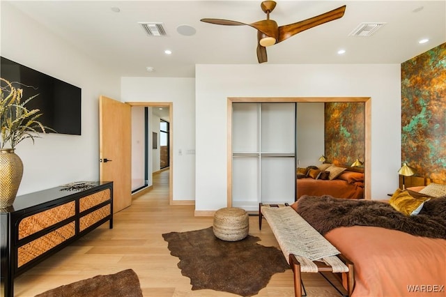 bedroom with light wood-style flooring, visible vents, a closet, and recessed lighting