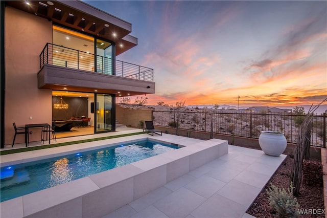 view of pool with a patio, fence, a fenced in pool, and an in ground hot tub