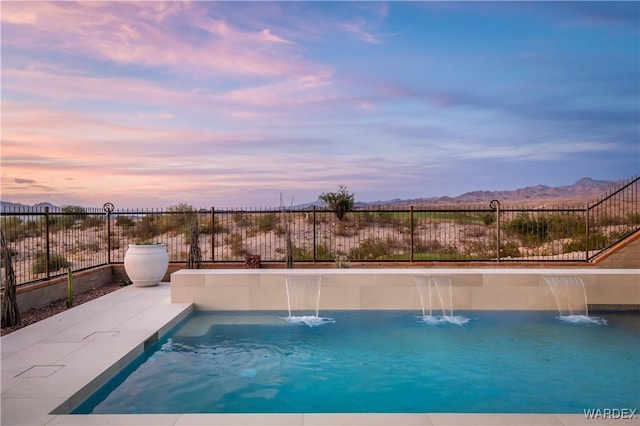 view of swimming pool featuring a fenced in pool, fence, and a mountain view