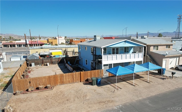 view of front facade with cooling unit, a fenced backyard, and a residential view