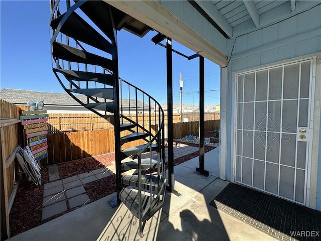 view of patio with a fenced backyard and stairway