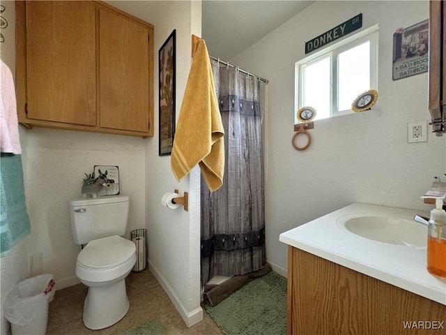 bathroom with toilet, curtained shower, baseboards, and vanity