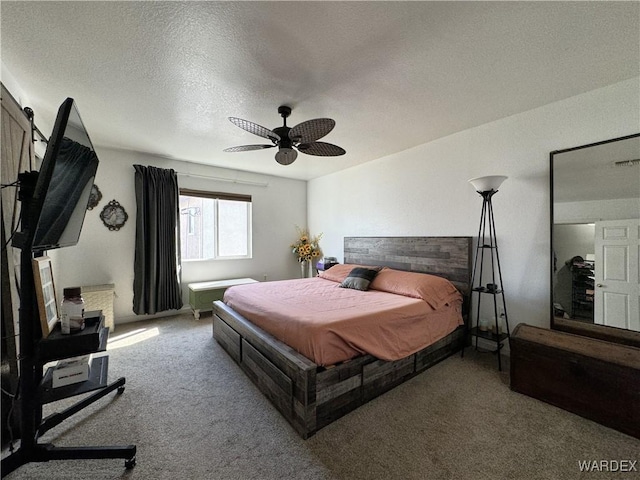 carpeted bedroom with a textured ceiling and ceiling fan