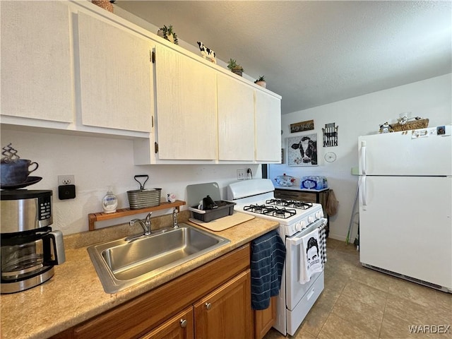 kitchen featuring white appliances, light countertops, and a sink