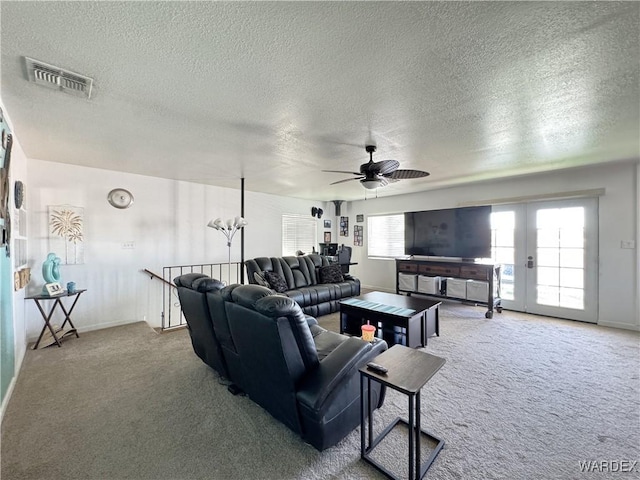 living area with carpet floors, french doors, visible vents, a ceiling fan, and a textured ceiling