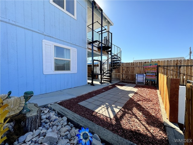 view of patio / terrace featuring stairs and fence