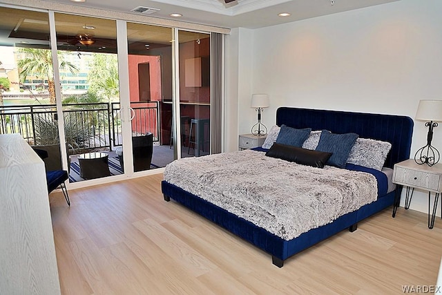 bedroom featuring access to outside, visible vents, and wood finished floors