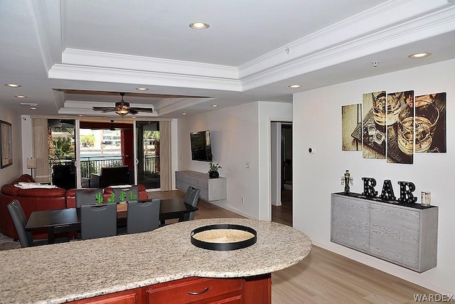 dining space with ceiling fan, recessed lighting, a tray ceiling, light wood finished floors, and crown molding