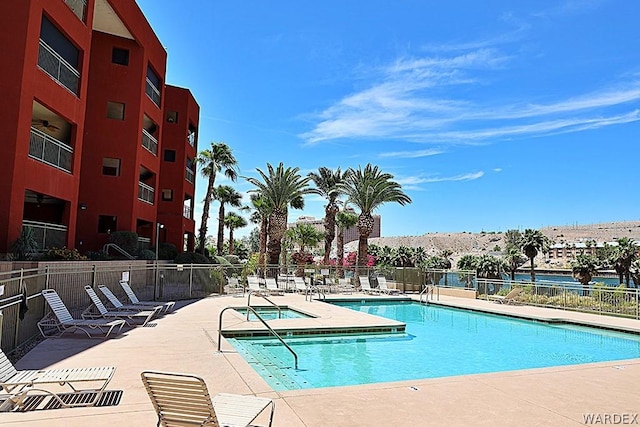 pool with a patio area and fence