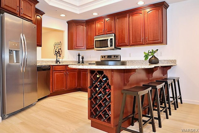 kitchen featuring crown molding, stainless steel appliances, light wood-style floors, and recessed lighting