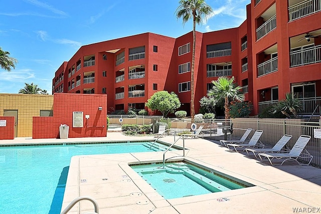 pool with a community hot tub, a patio area, and fence