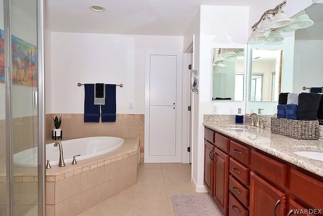 full bath with a garden tub, tile patterned flooring, a sink, a shower stall, and double vanity