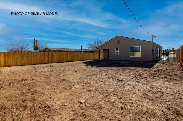 view of side of home with a fenced backyard and stucco siding