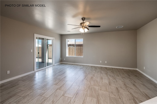empty room with a ceiling fan and baseboards