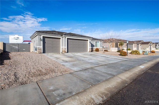 single story home with a garage, fence, concrete driveway, stone siding, and a residential view