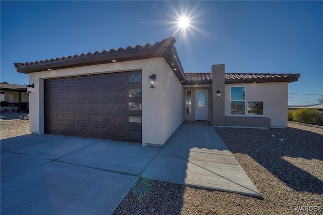 mediterranean / spanish-style house with concrete driveway, an attached garage, a tile roof, and stucco siding