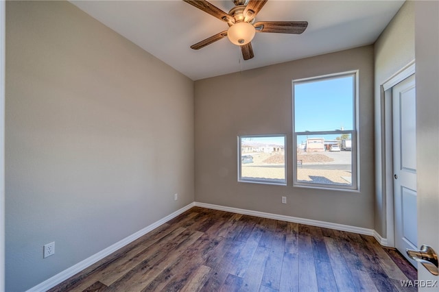 spare room with a ceiling fan, dark wood-style flooring, and baseboards