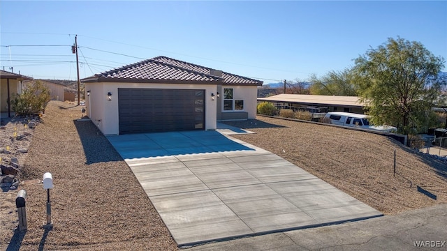 view of front of house featuring a tiled roof, concrete driveway, and stucco siding