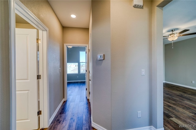 hall featuring dark wood-style floors and baseboards