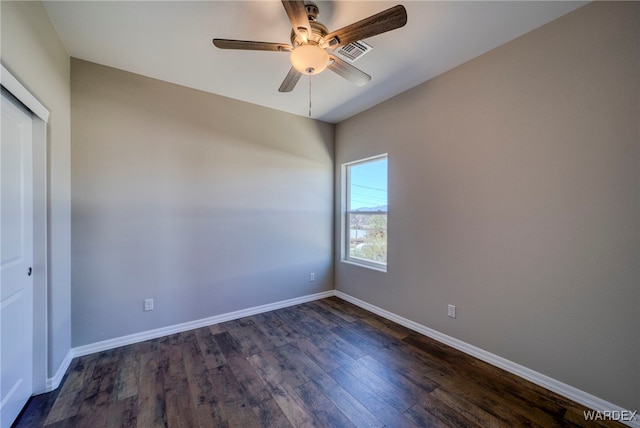 unfurnished room featuring ceiling fan, dark wood-style flooring, visible vents, and baseboards