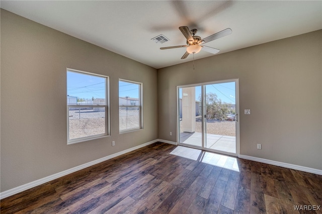 unfurnished room featuring ceiling fan, visible vents, baseboards, and dark wood finished floors