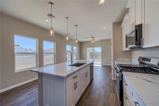 kitchen featuring a kitchen island with sink, appliances with stainless steel finishes, a sink, and white cabinetry