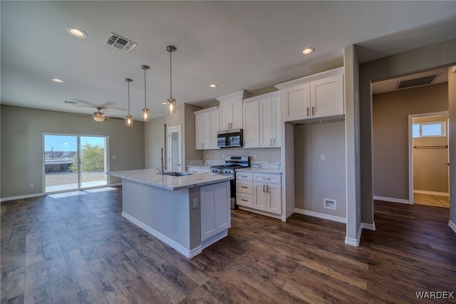 kitchen with a kitchen island with sink, a sink, white cabinetry, appliances with stainless steel finishes, and pendant lighting