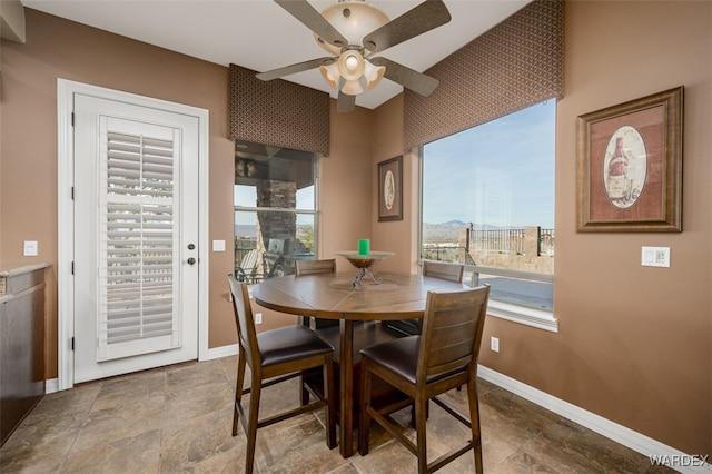 dining space featuring baseboards, ceiling fan, and a healthy amount of sunlight