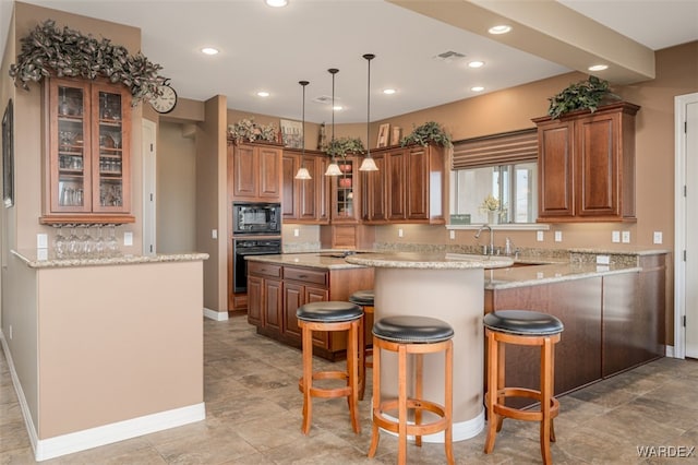 kitchen with a peninsula, visible vents, brown cabinets, black appliances, and glass insert cabinets