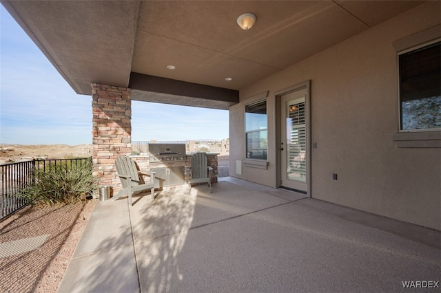 view of patio with area for grilling and a grill